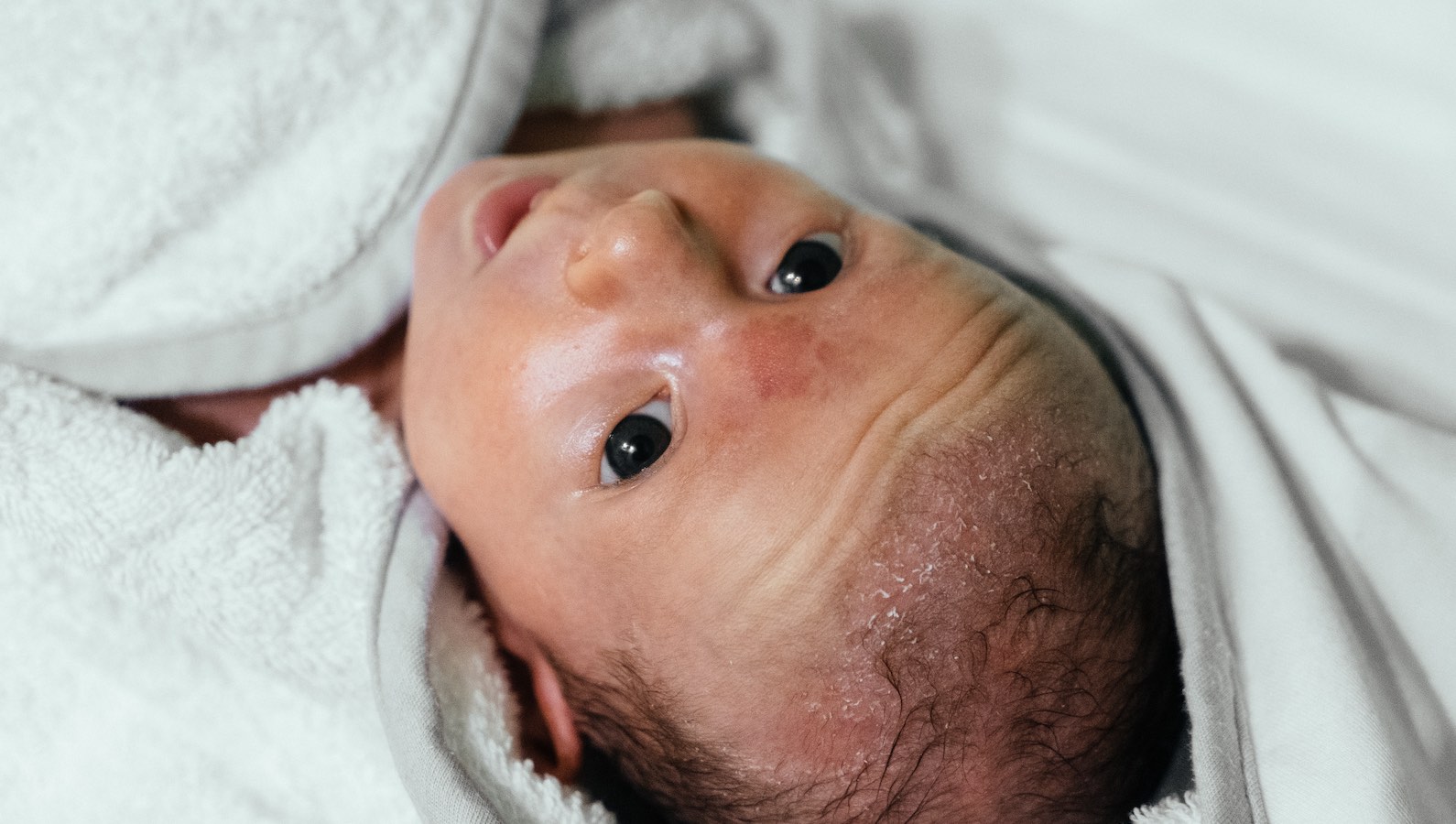 Baby covered in blanket after bathing