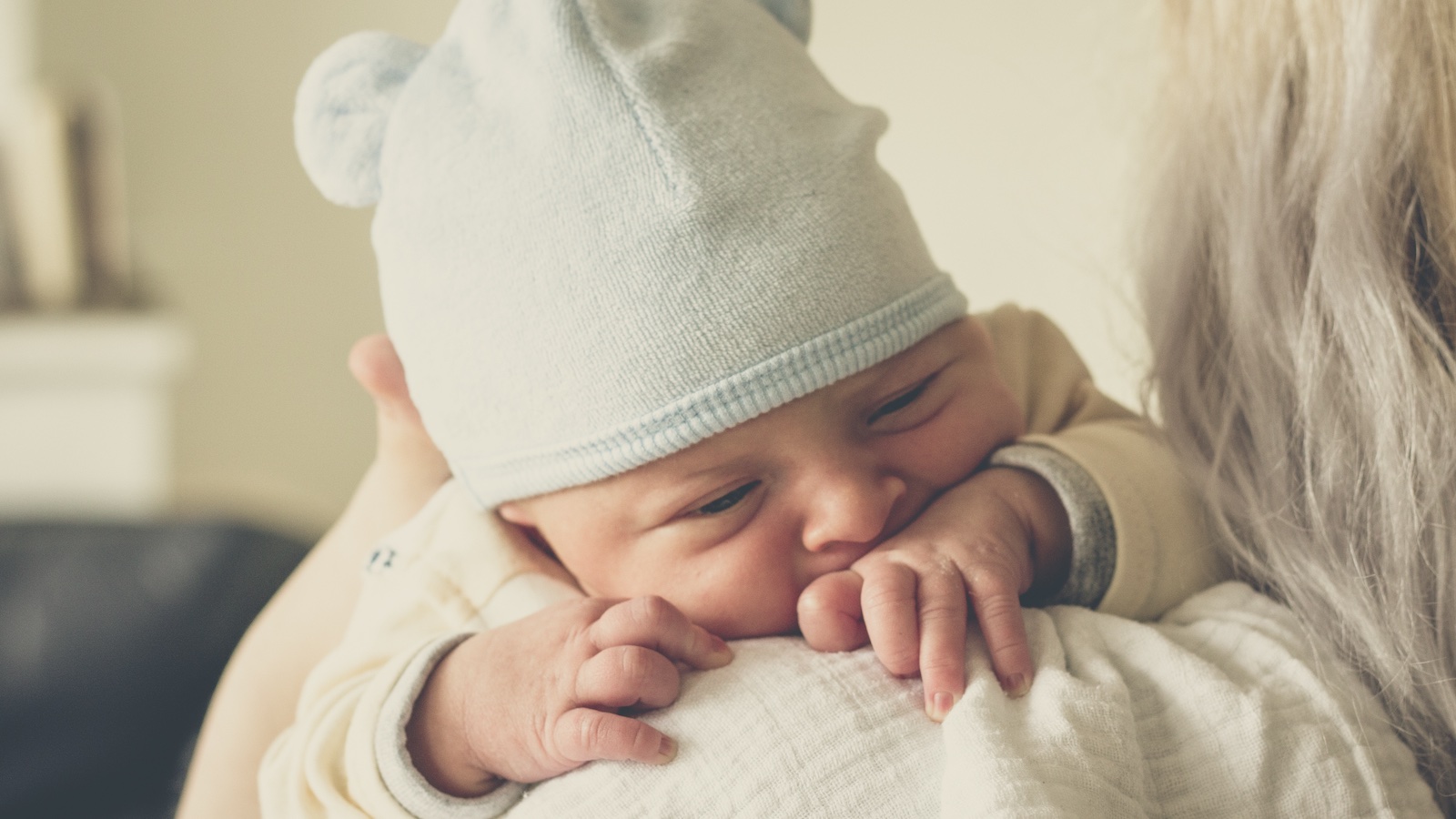 Burping by placing your  baby on your shoulder with their chin resting on your shoulder.